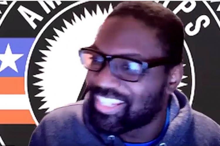 Pierre in front of the AmeriCorps logo