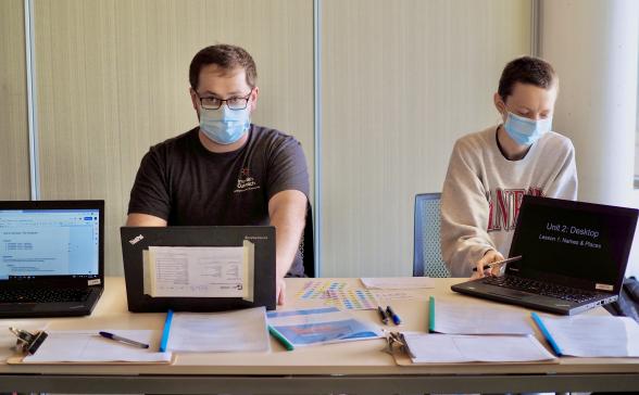 Two people at a table with laptops