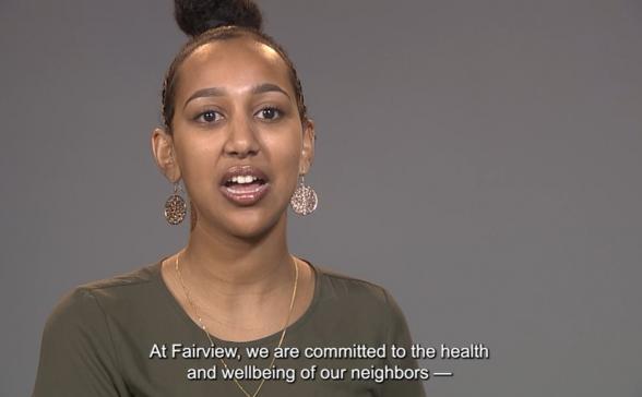 A still shot of the video. It is an gray background with a woman in the left two thirds of the screen. At the bottom of the image is text from the video. 