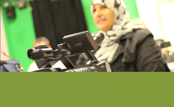 A photo of a woman in a hijab with a camera