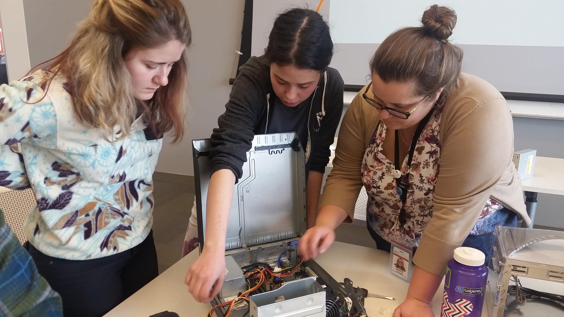 Three woman dissecting wires