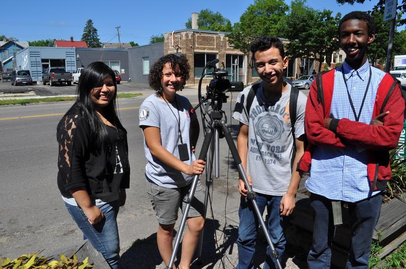 Four people posing with a camera