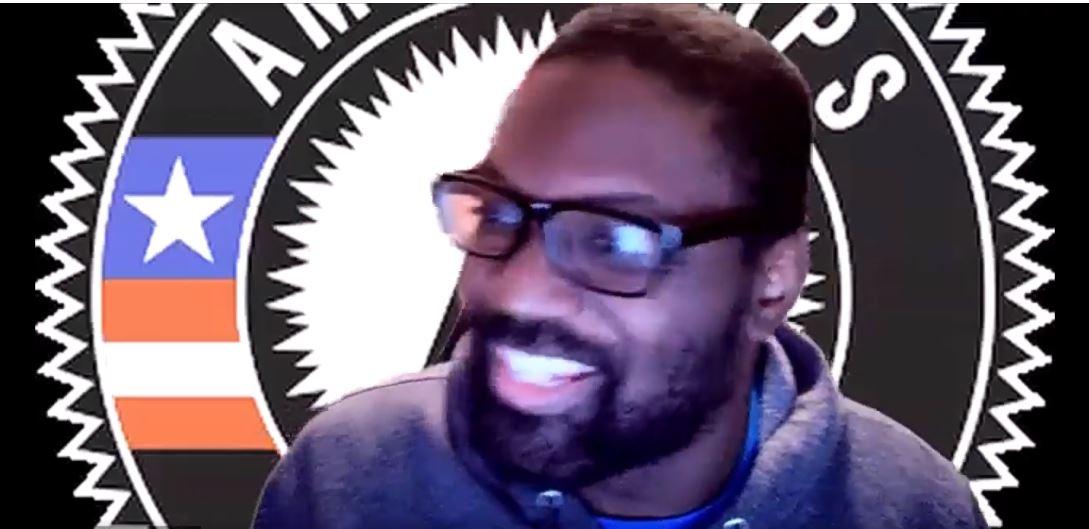 Pierre in front of the AmeriCorps logo