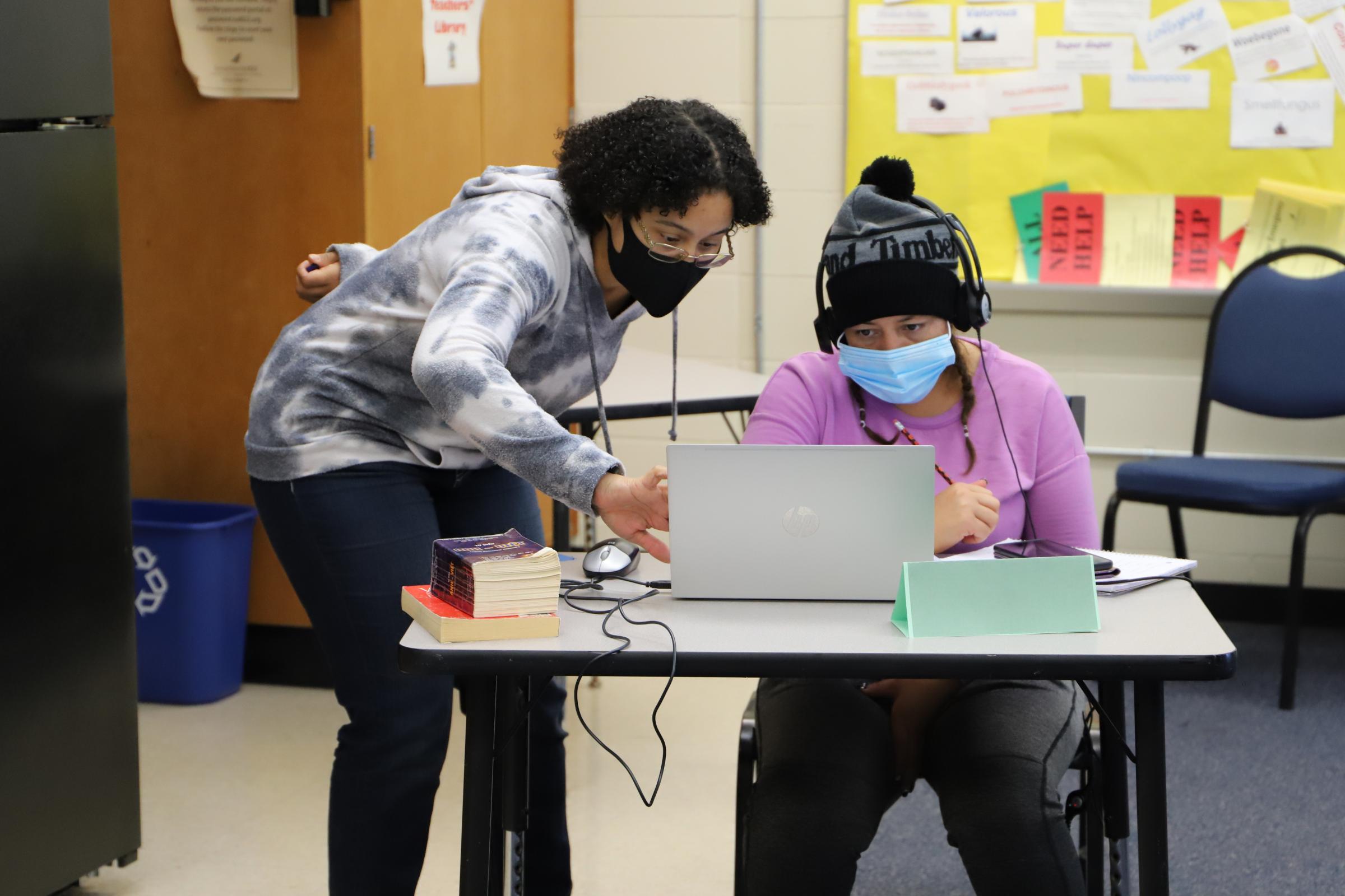 CTEP member teaches technology skills to a student using a laptop