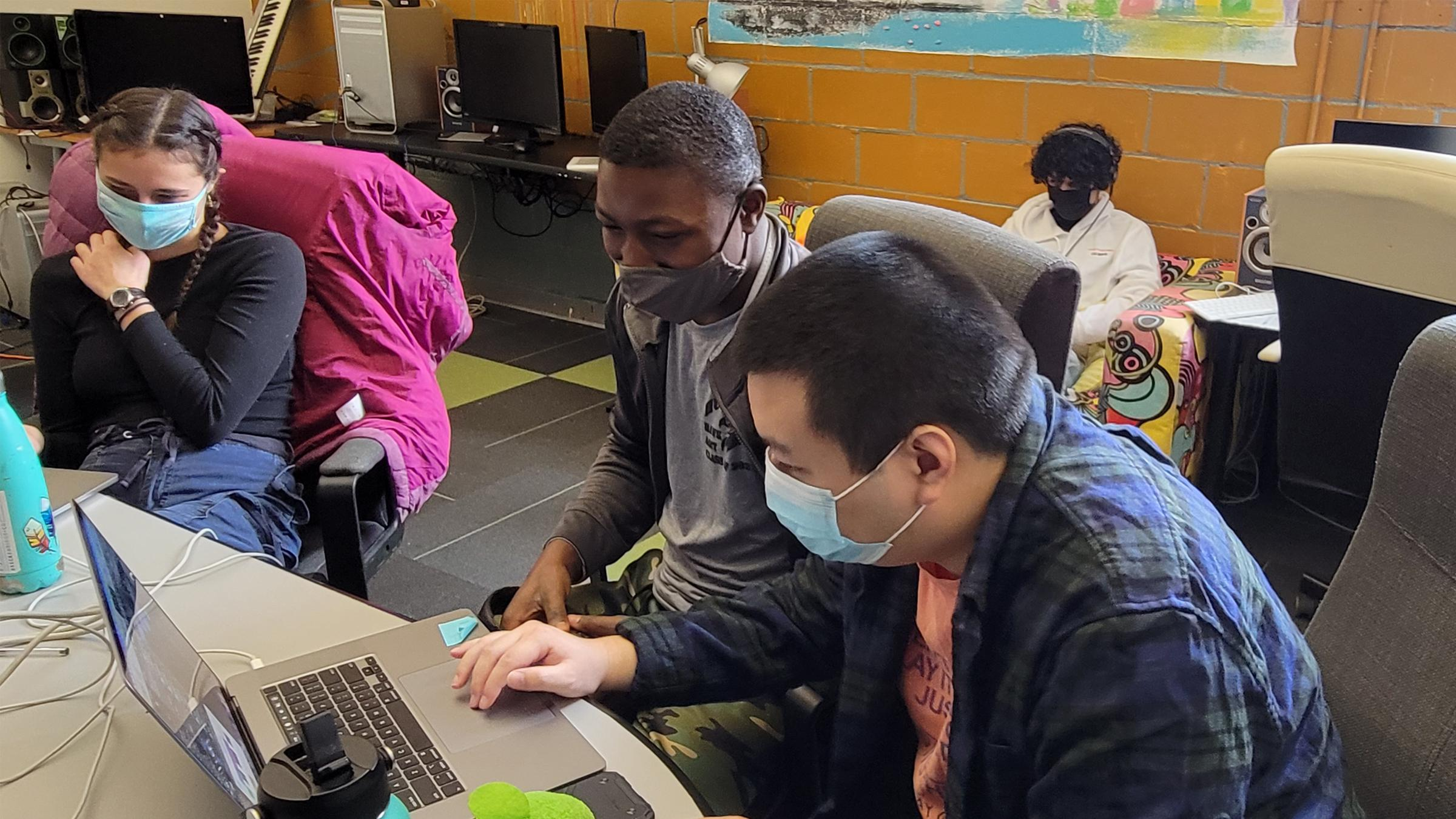 SPNN youth and staff work on a project on a laptop