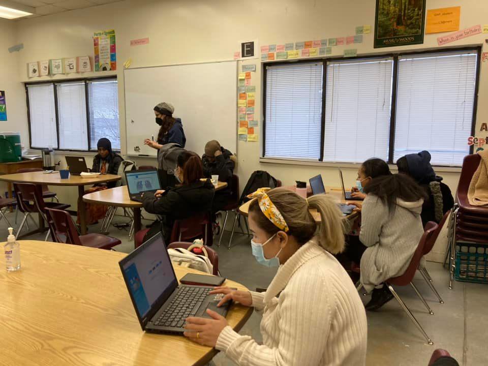 CTEP member teaches technology skills to a classroom of students using laptops