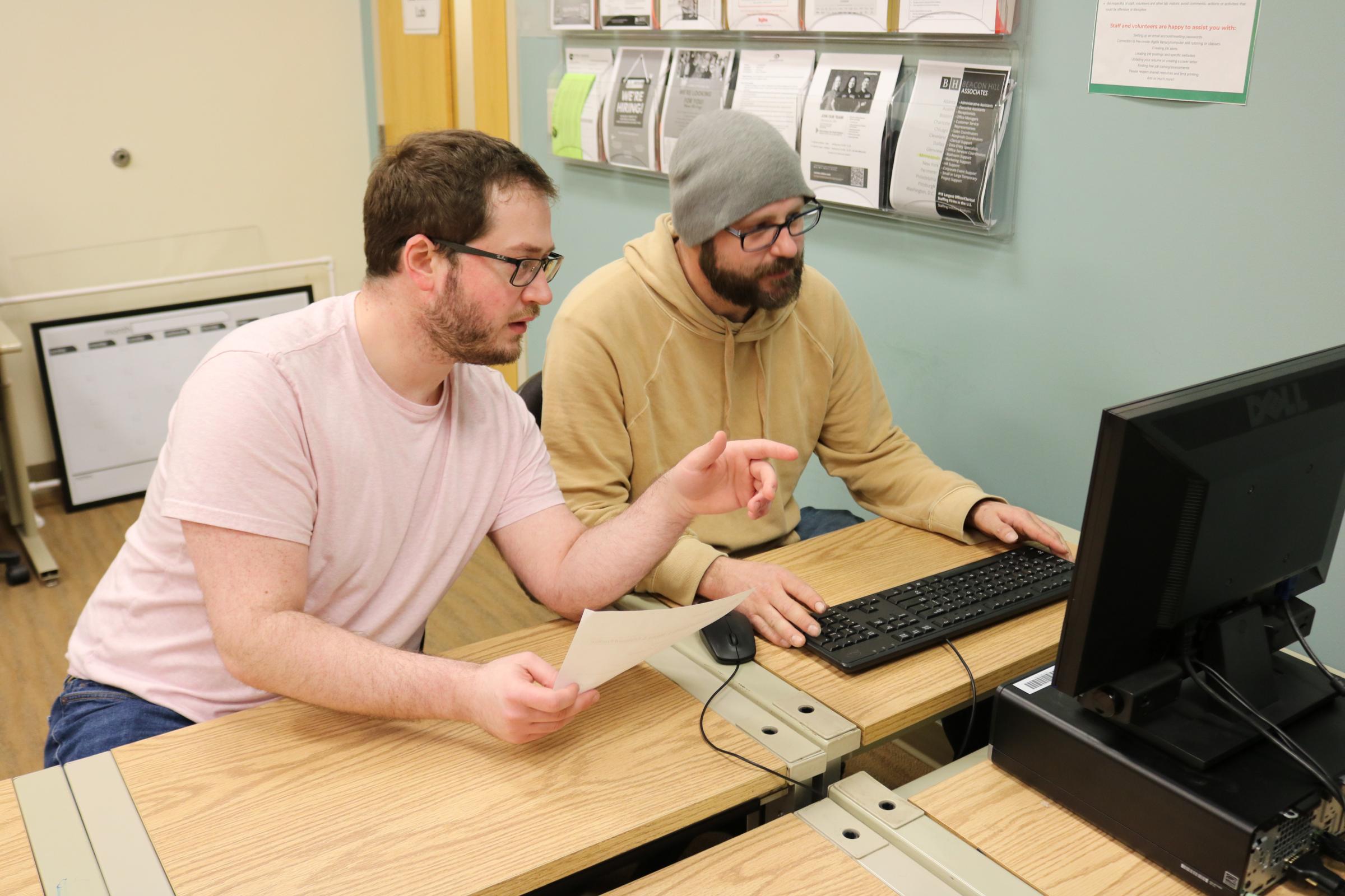 CTEP member assisting a client at a desktop computer in the computer lab.